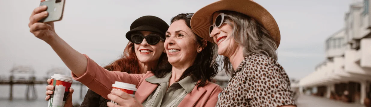 Drei Frauen in der Lebensmitte lachen gemeinsam – Verbundenheit und Lebensfreude